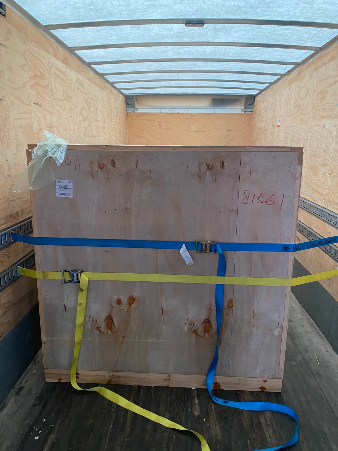 A real oversized wooden equipment crate secured inside an enclosed trailer