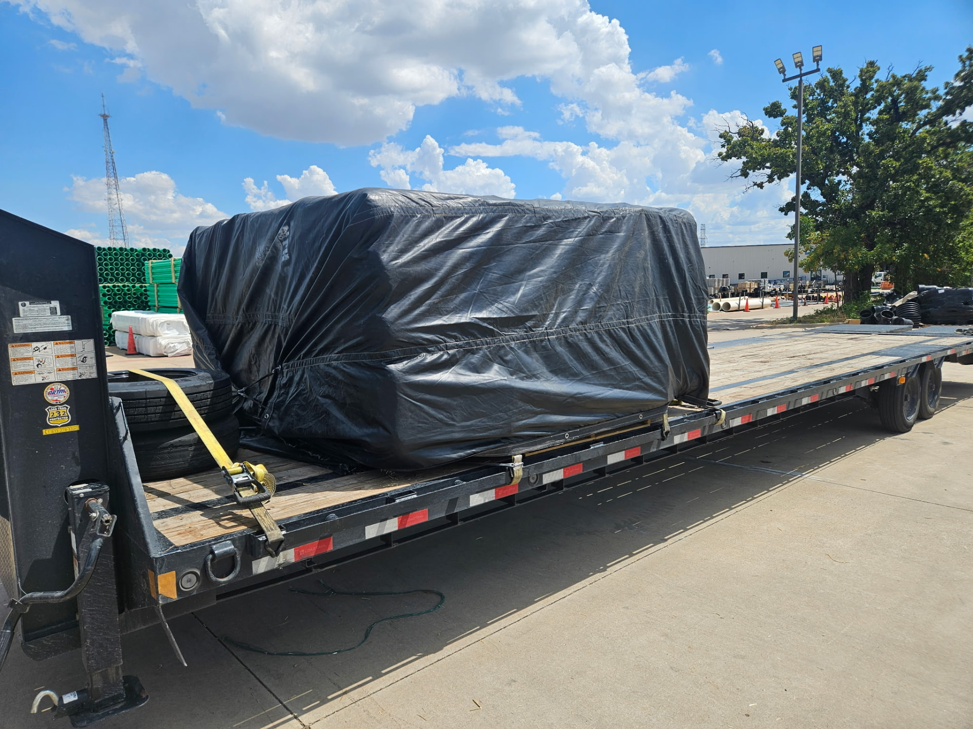 A real tarped freight load secured to a long flatbed trailer